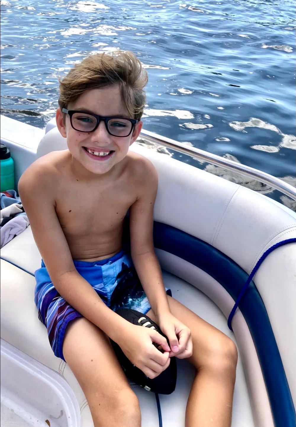 Brayden grinning on a boat out on the water